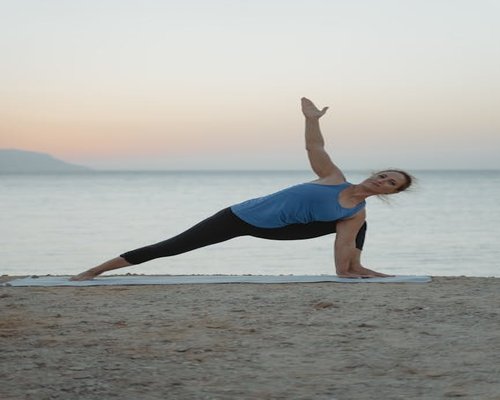 Person doing gentle yoga stretching at sunrise